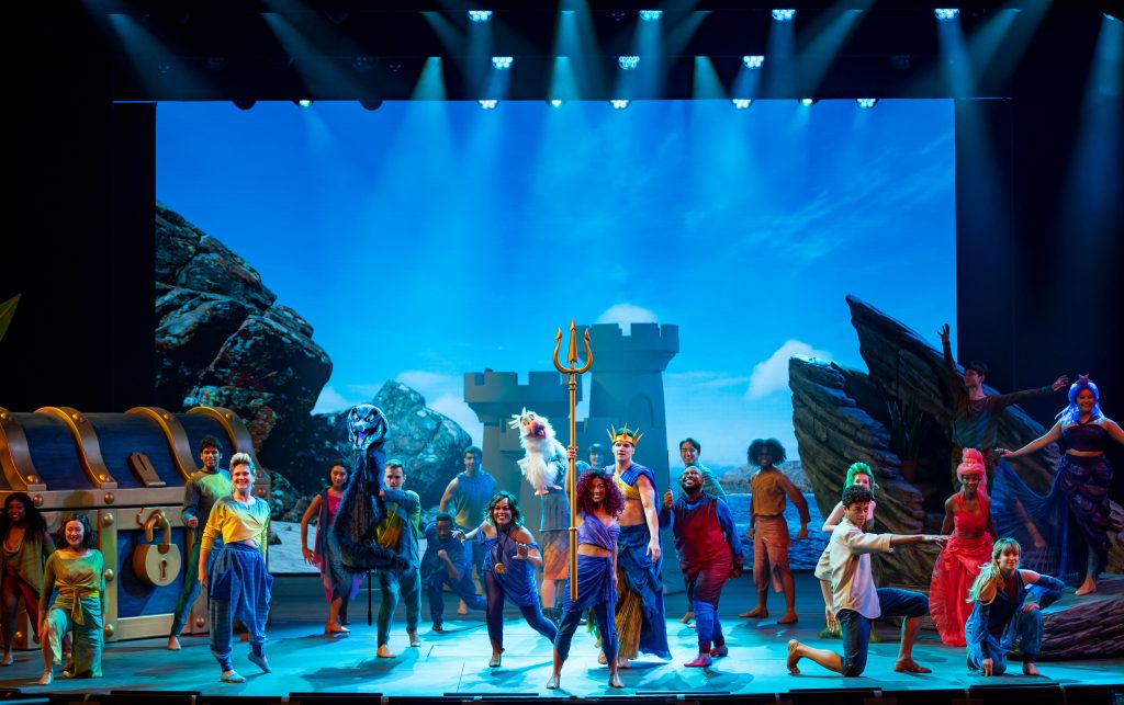 Ensemble posing during theatrical production of The Little Mermaid onboard the Disney Wish cruise ship