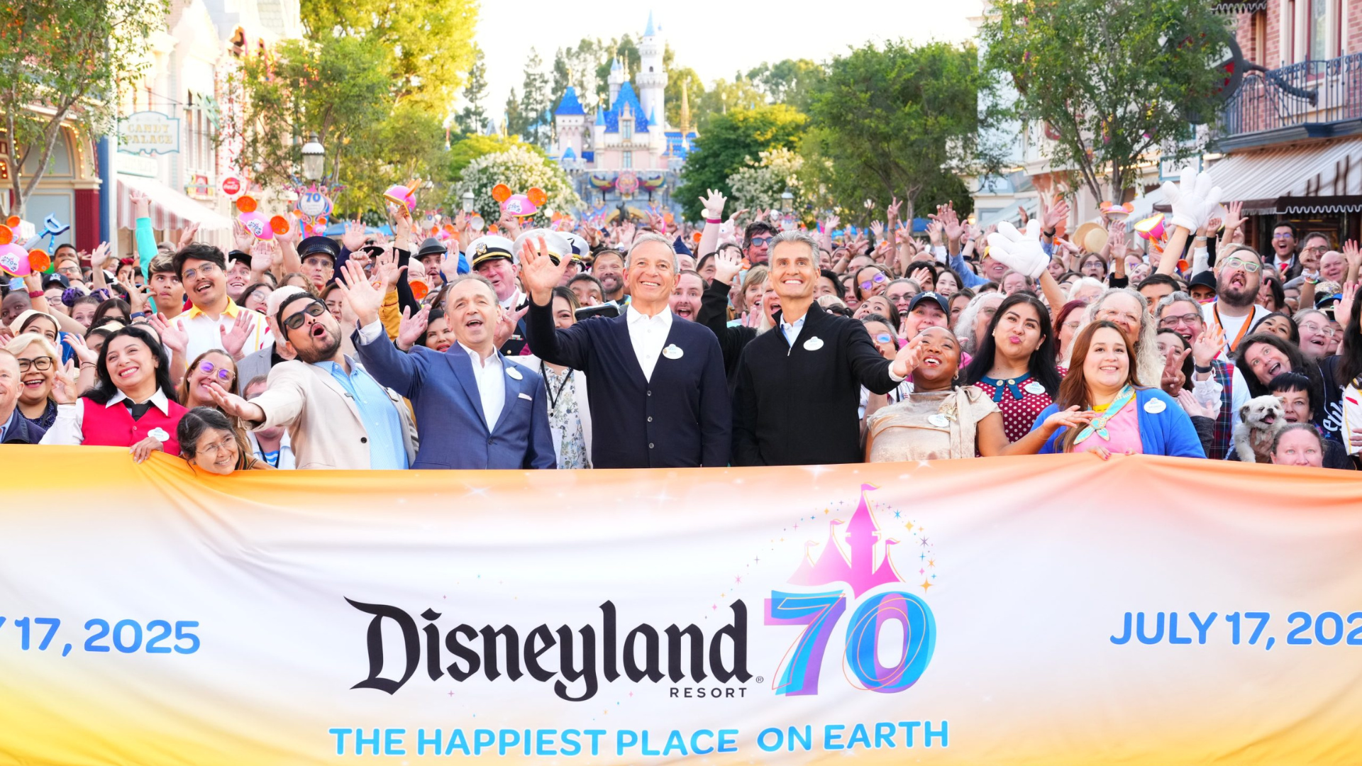 Bob Iger, Josh D'Amaro, and Thomas Mazloum stand on Main Street U.S.A. at Disneyland with Disneyland cast members.