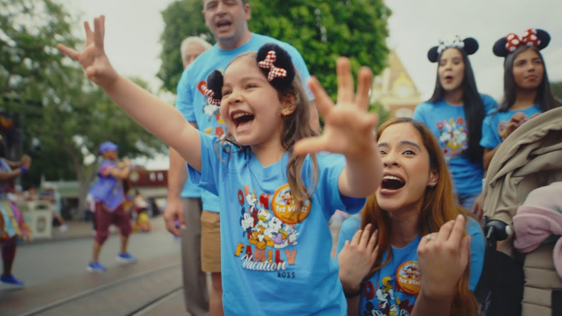 A little girl and her family are excited about something off screen at Disneyland