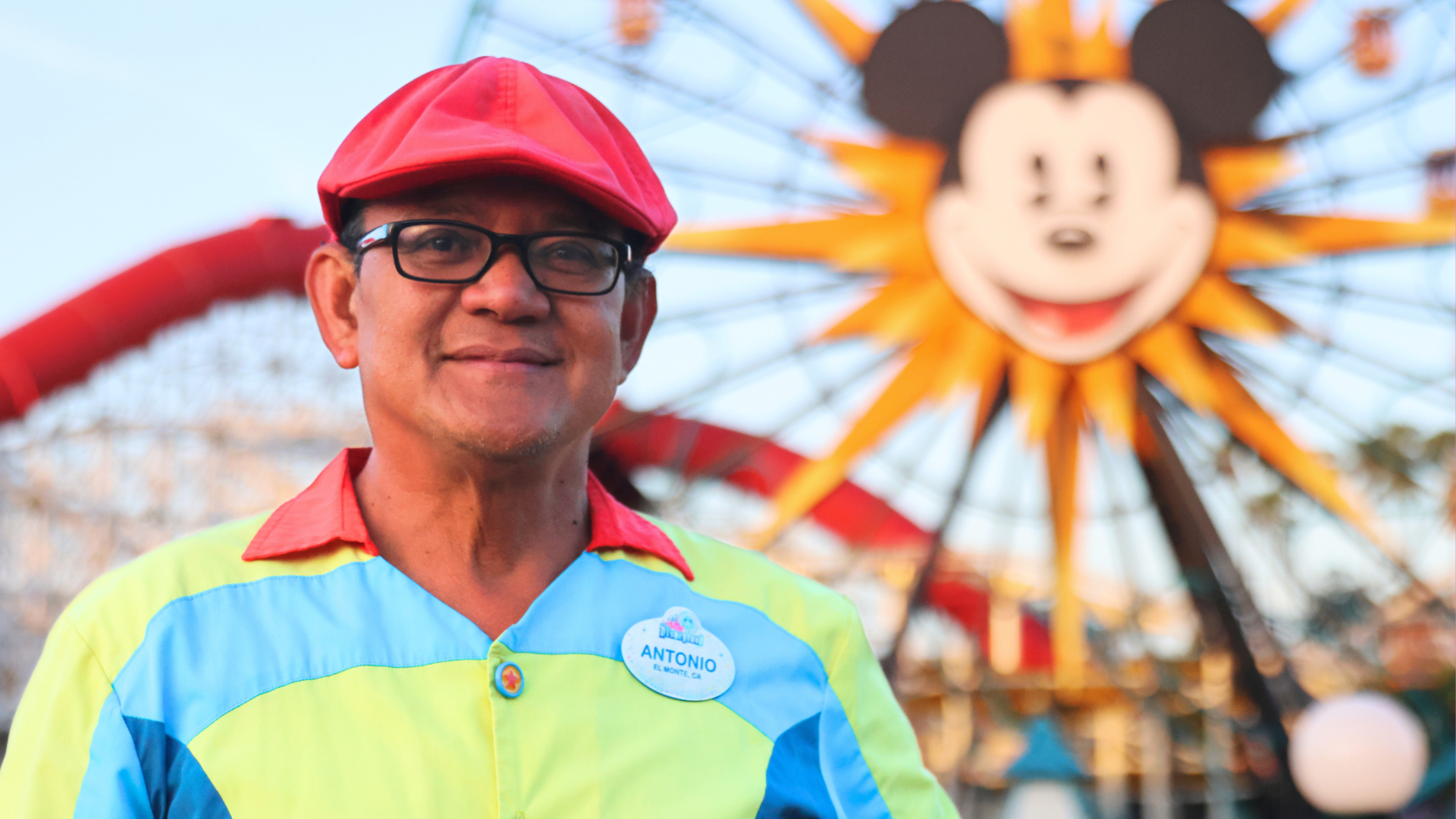 Disneyland cast member Antonio stands in front of the Mickey Mouse ferris wheel.