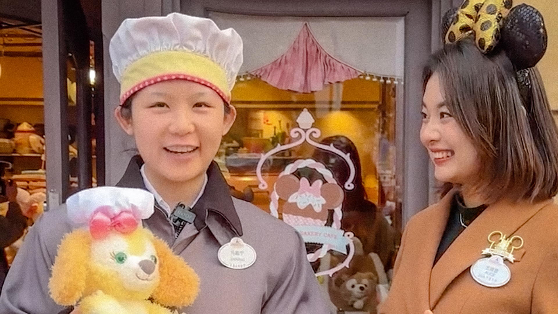 Two Disney cast members smiling, one wearing a chef's hat, another in mouse ears