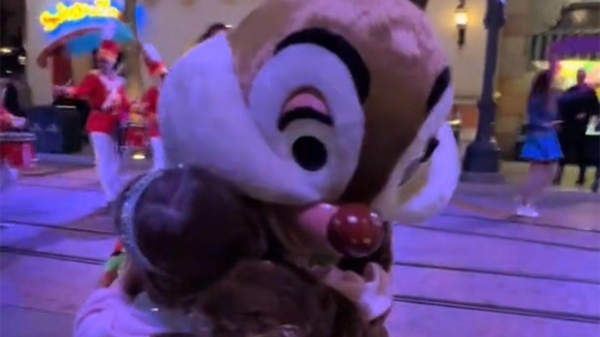 A young girl hugs Dale during a Disney Parade