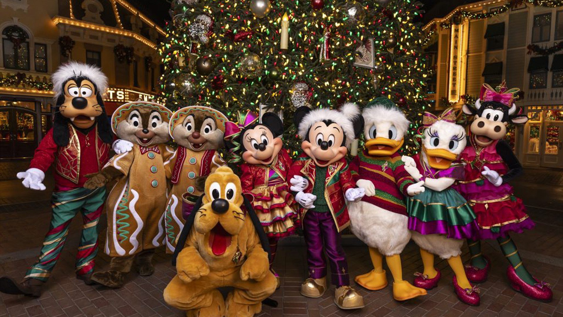Pluto, Minnie, Mickey, Donald, Daisy and Clarabelle stand in front of the Christmas tree on Main Street U.S.A.