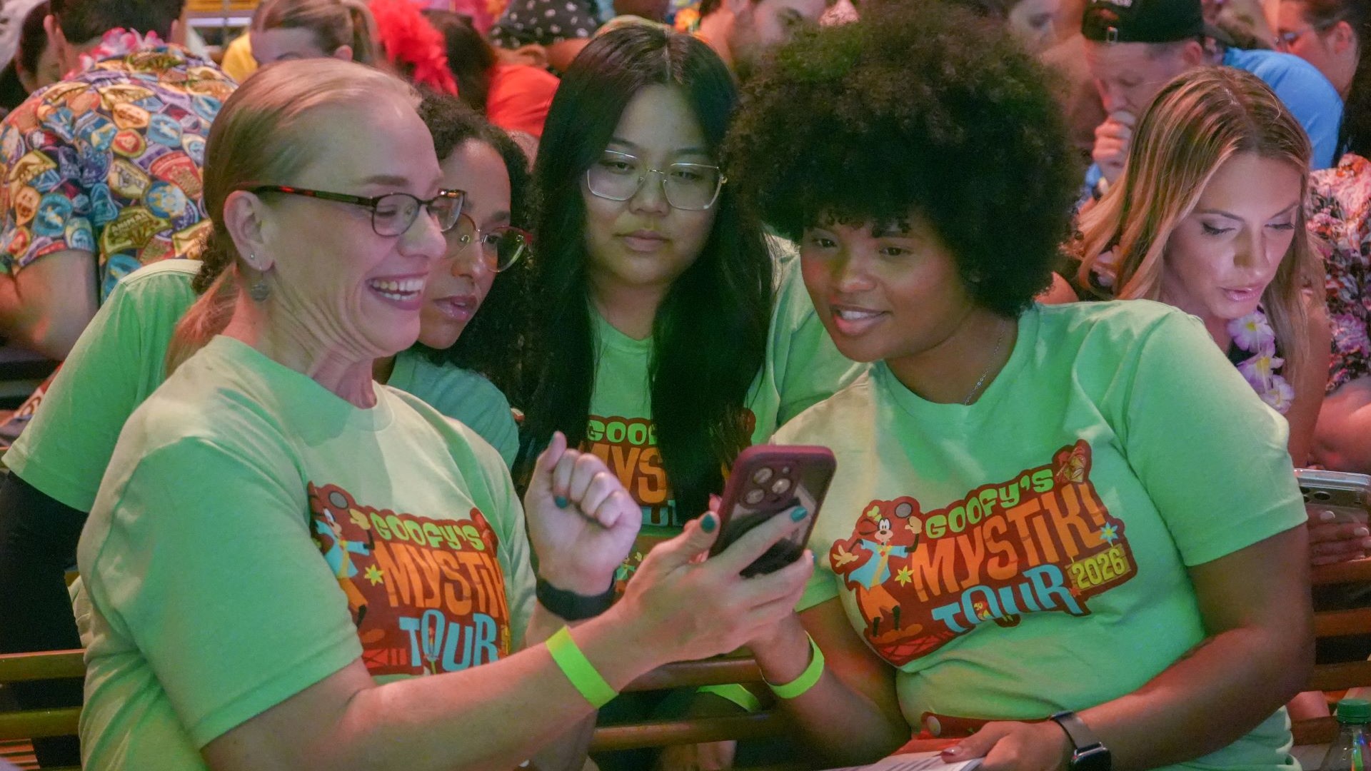 Cast Members looking at phone screen at Goofy's Mystiki Tour