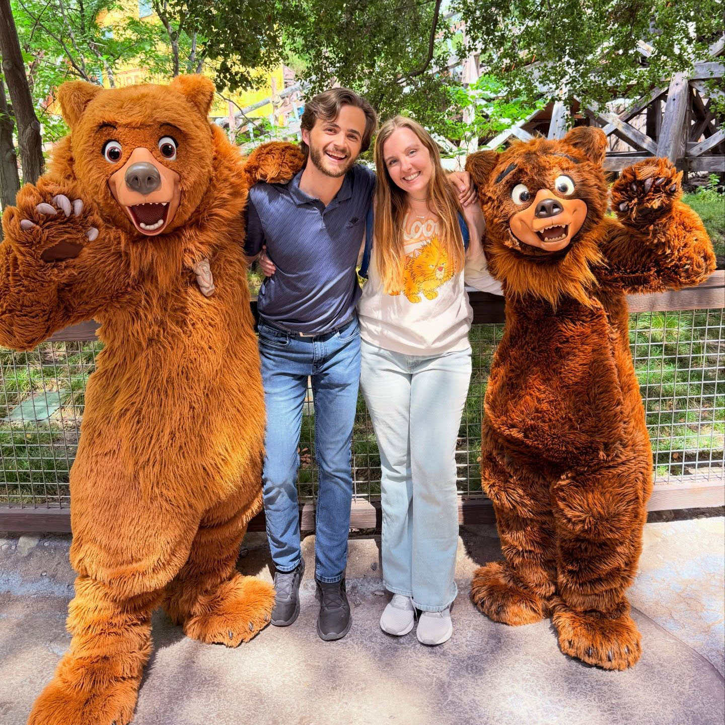 A man and woman pose with Kenai and Koda from Brother Bear