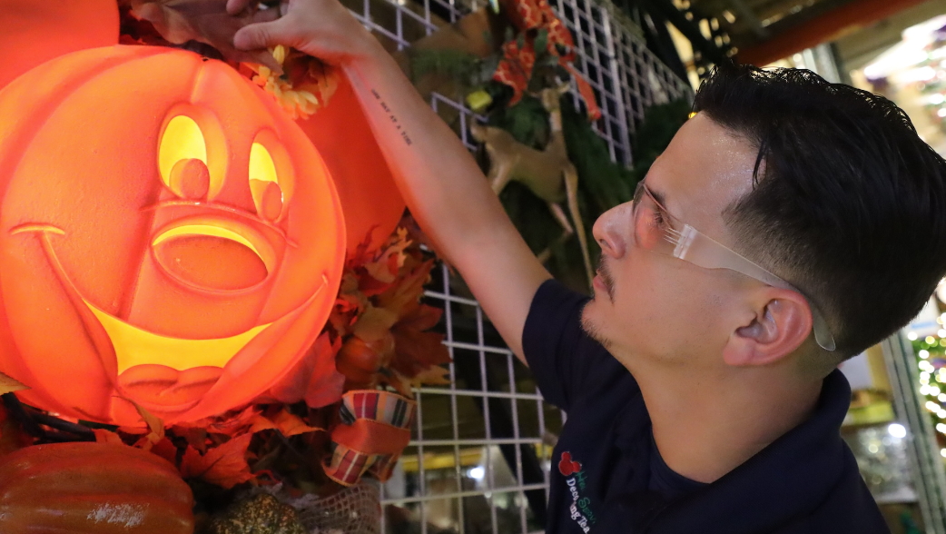 Cast Member fixing pumpkin