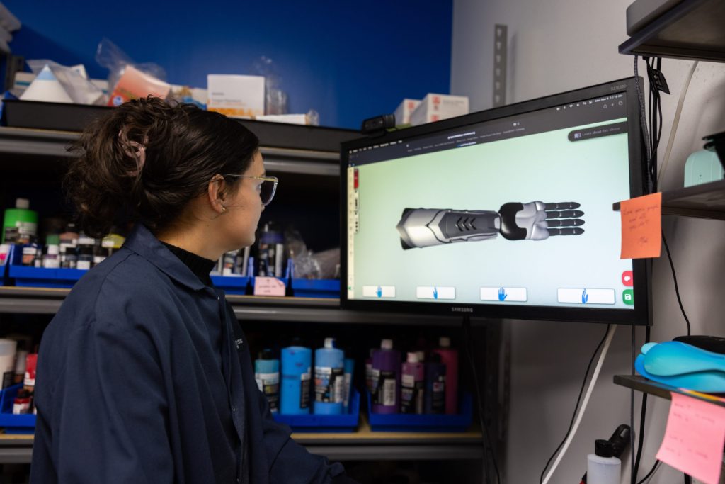 Person at a computer terminal designing a bionic arm