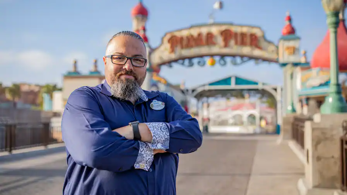 Robert standing with his arms crossed in front of Pixar Pier.