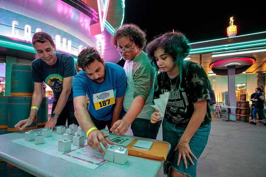 Group of four contestants in Cars Land trying to figure out one of the puzzles.