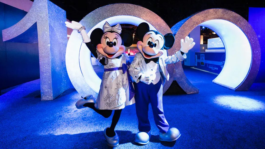 Mickey and Minnie pose with 100 numbers.