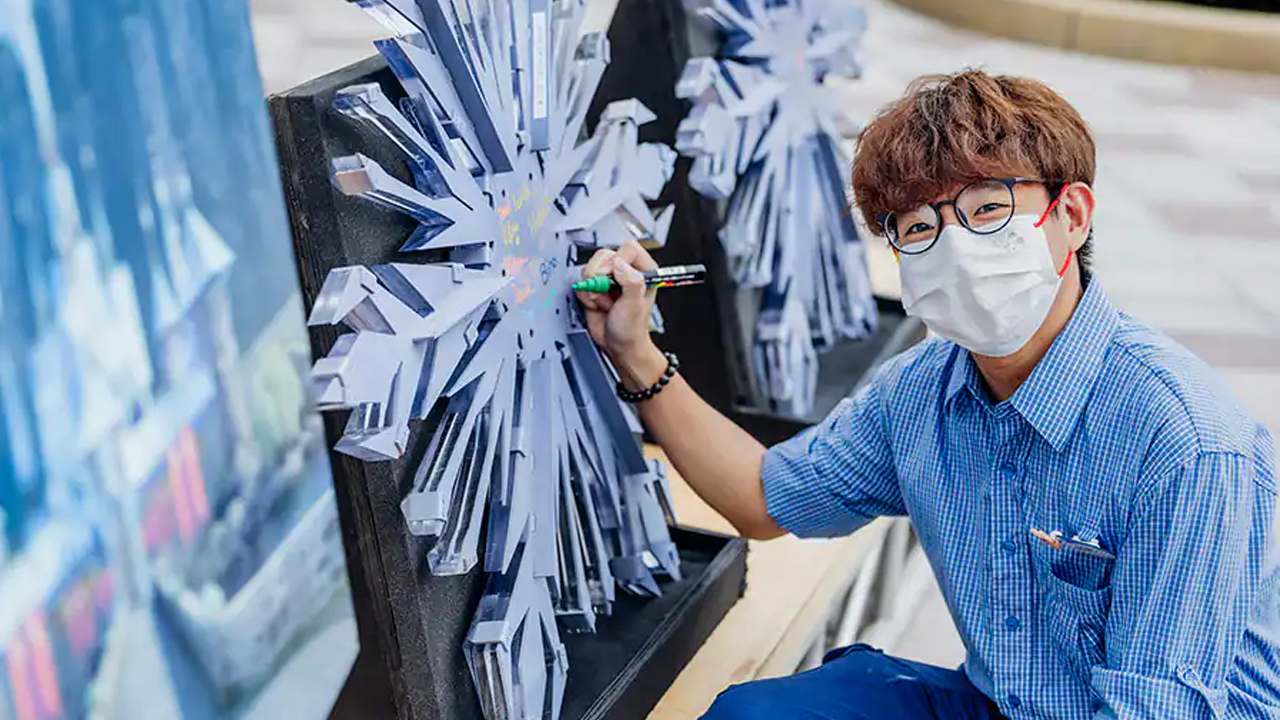 Cast Members signing the snowflake. 