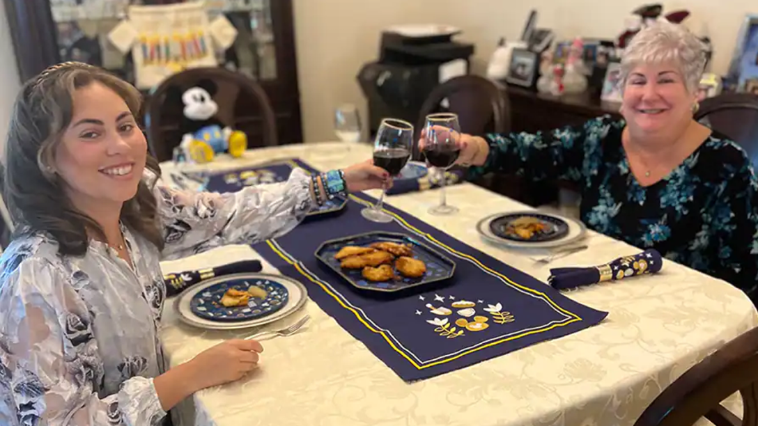 Rachel and her mom toasting at the dining room table.