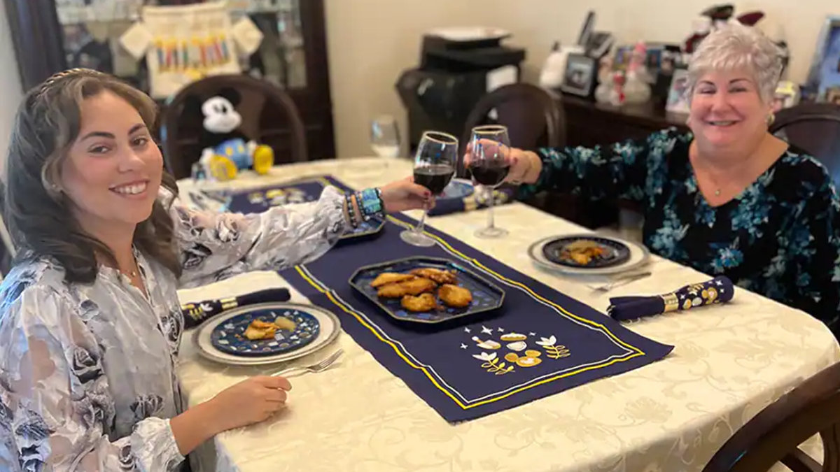 Rachel and her mom toasting at the dining room table.