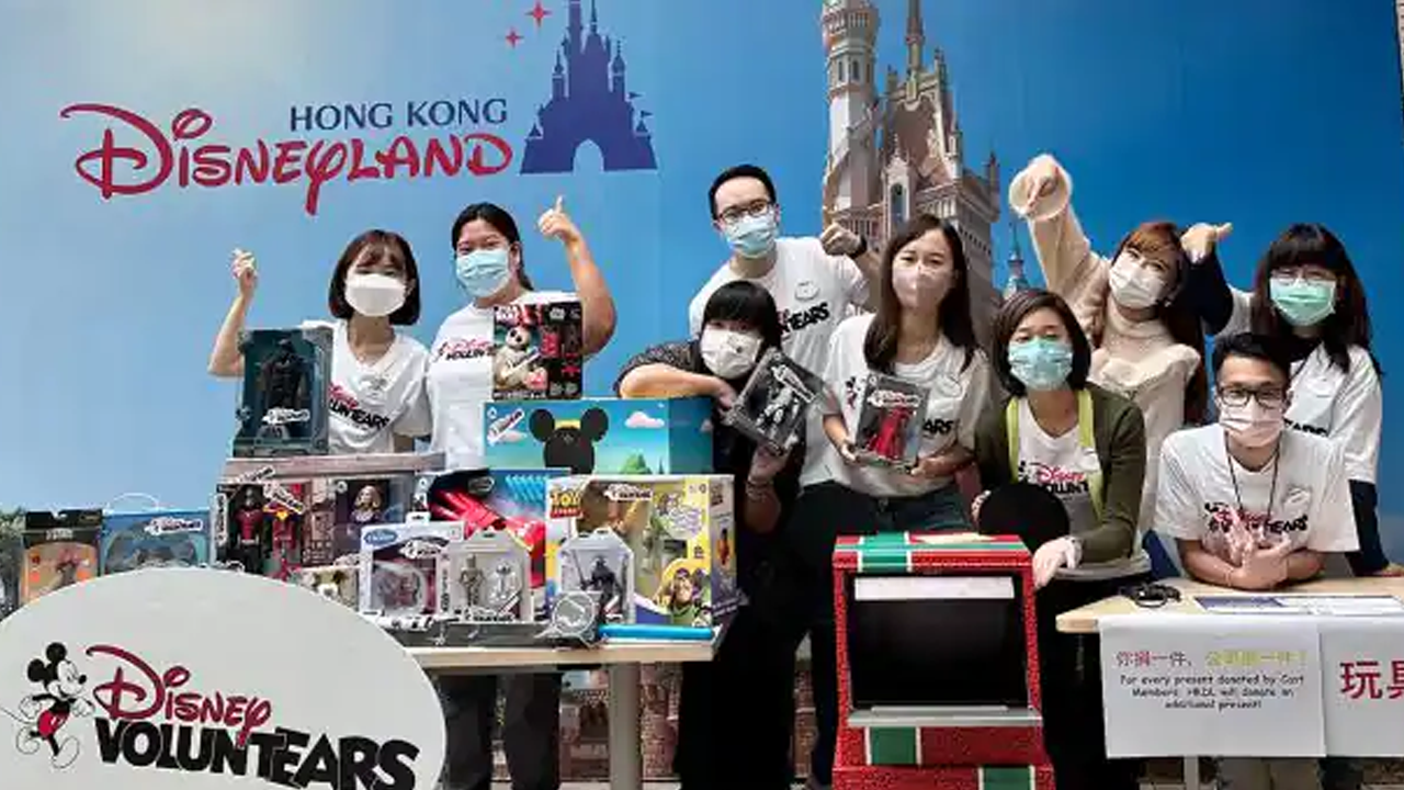Cast Members pose with toys being donated. 