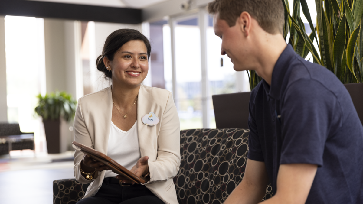 Disney Cast Member sitting on a couch meeting with a new coworker.