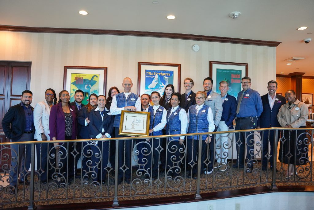 Surrounded by fellow cast members and leaders, Robert was gifted a personalized illustration celebrating him as a "Service Champion."