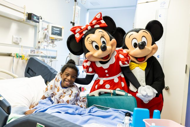 Mickey Mouse and Minnie Mouse share smiles with a CHOC patient.