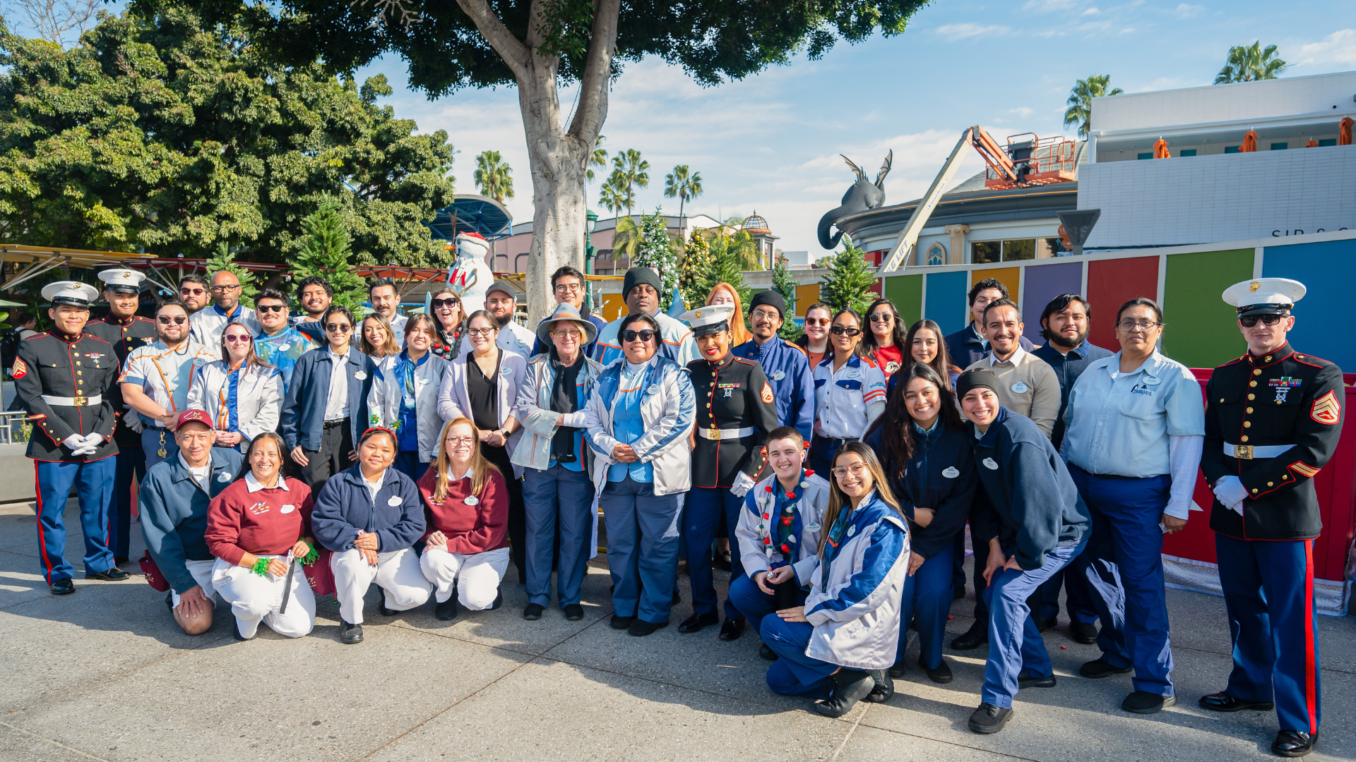 Tomorrowland cast members join together for a group photo with U.S. Marines after dropping off donated toys at the Toys for Tots donation bin in Downtown Disney District.