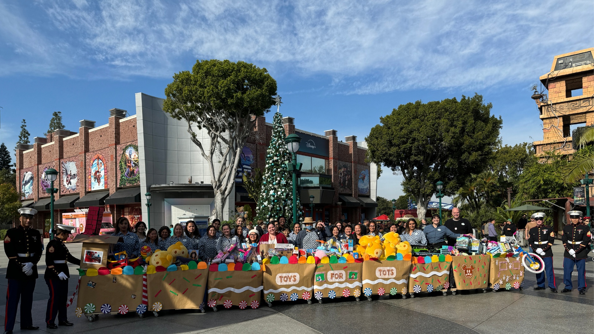 Cast come together with U.S. Marines to capture a photo of their donation in Downtown Disney District.