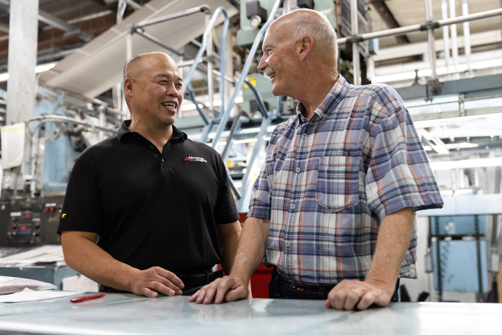 Tom (left) and Les, one of Advantage ColorGraphics’s longest standing employees, share a laugh in the company’s warehouse.