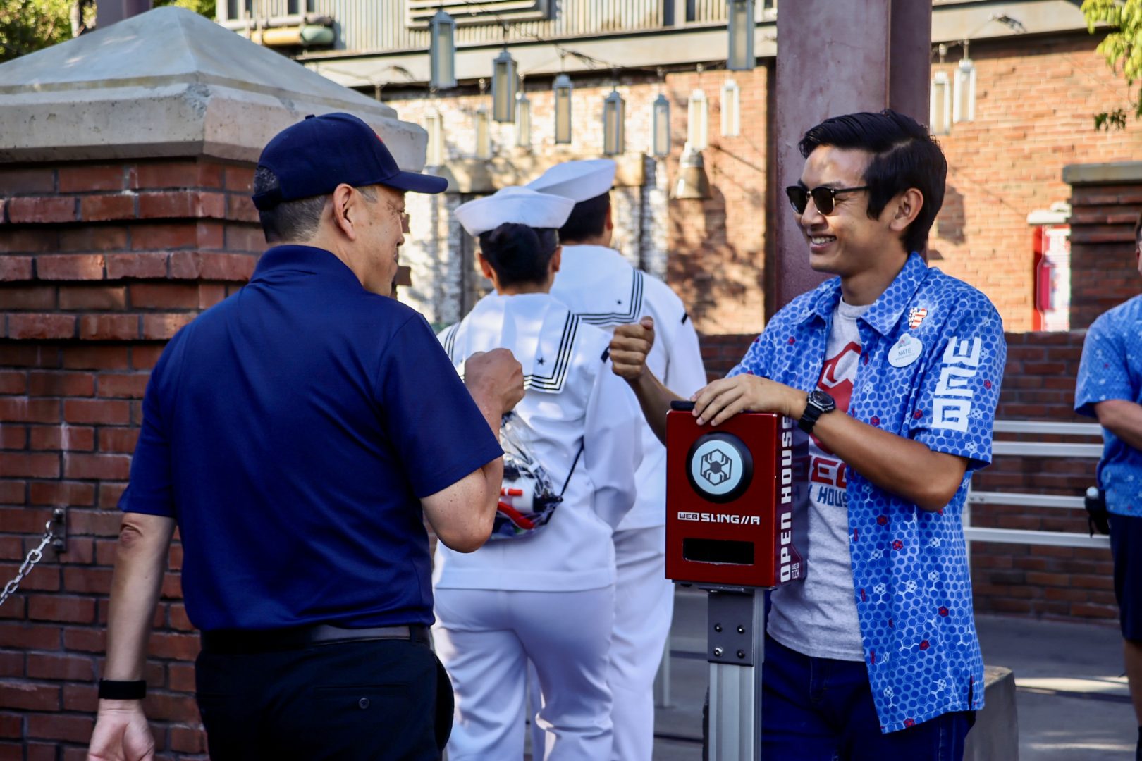 Retired U.S. Navy public affairs officer Ken (left) shares a proud moment with his son Nate (right) while entering WEB SLINGERS: A Spider-Man Adventure. 